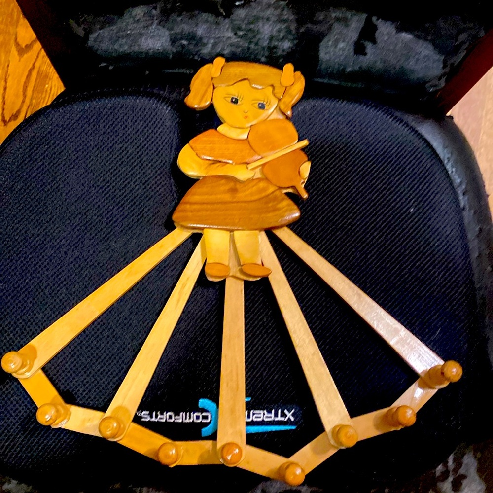 Vintage wooden coatrack expandable with pegs. Features a girl playing a violin.